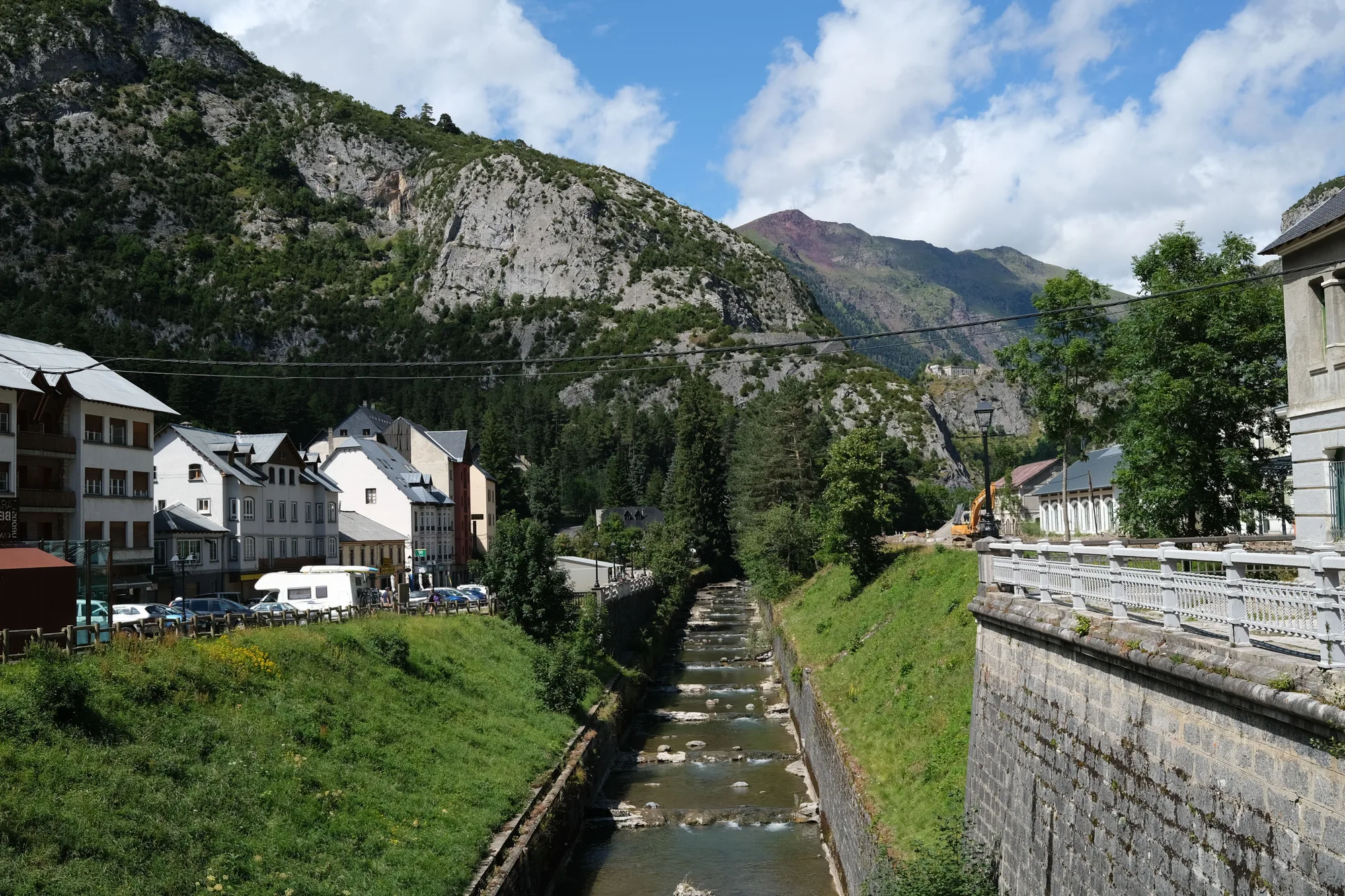 Un paese di montagna attraversato da un canale, in una giornata d'estate