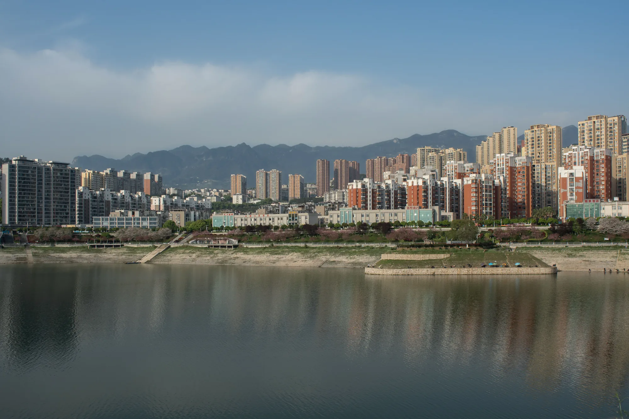 Il profilo di una città sul fiume, con le montagne dietro
