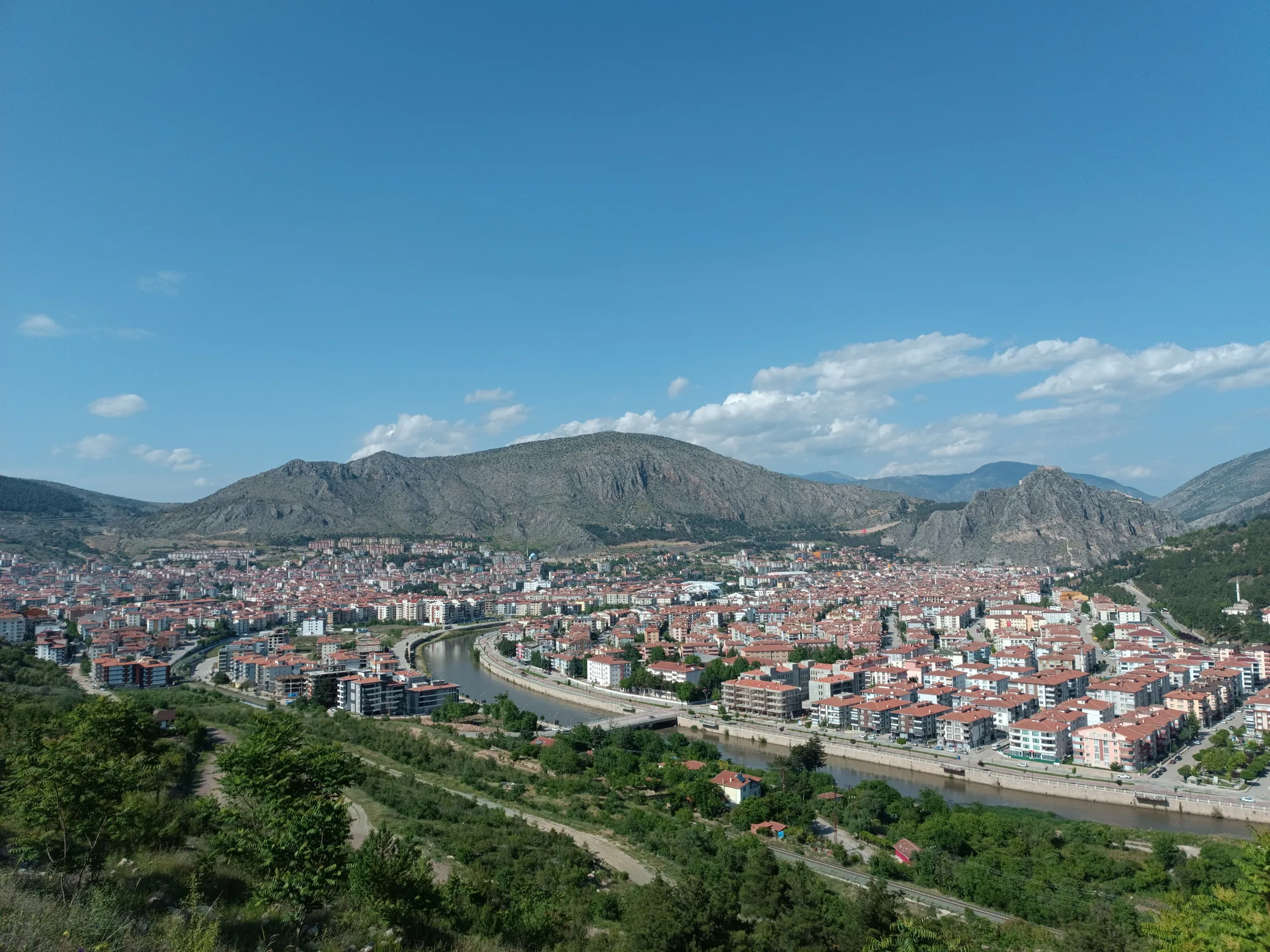 Una città incassata fra il verde e le montagne, sotto il cielo sereno