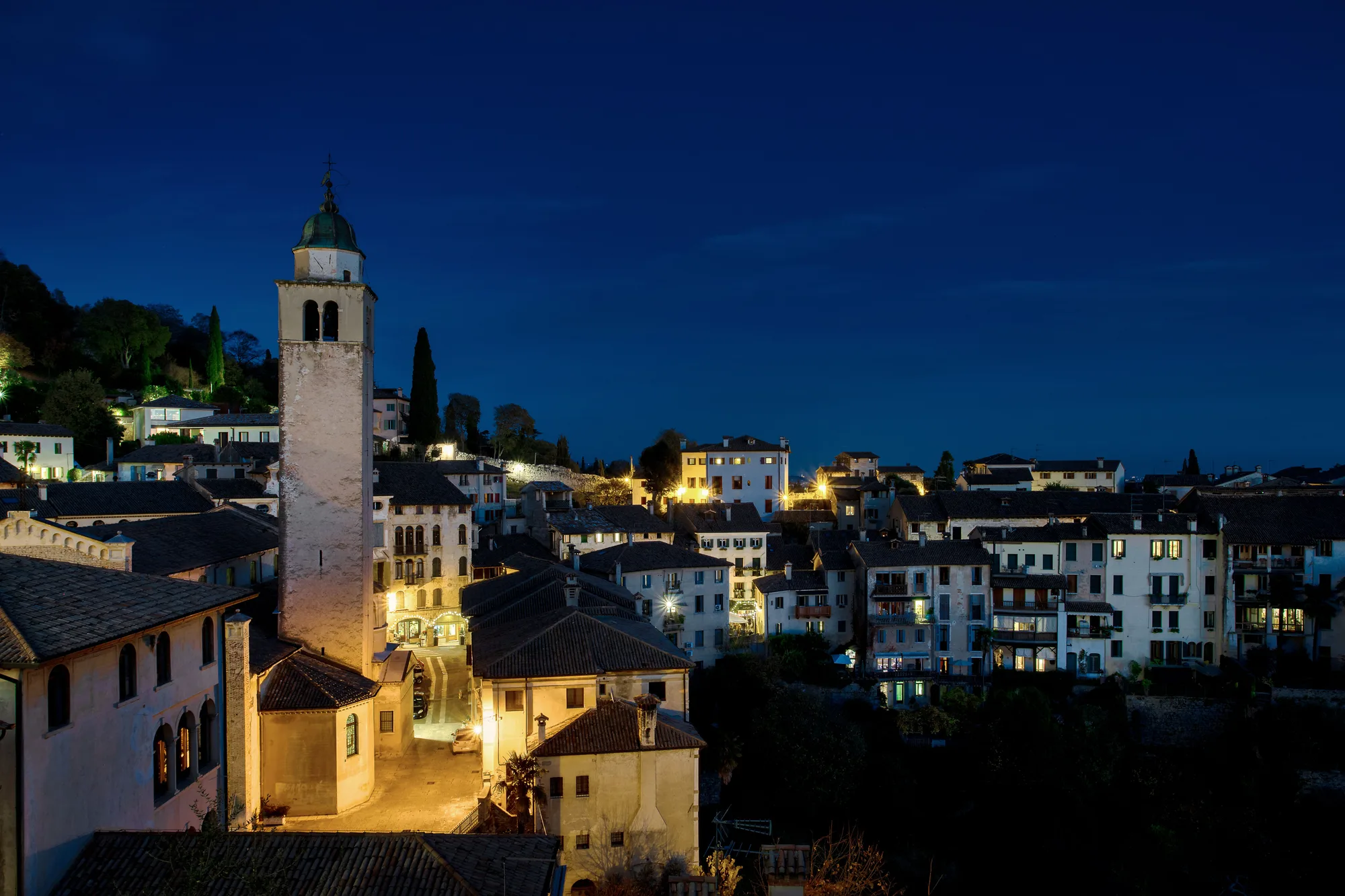 Un paese italiano di notte, con le luci e l'architettura classica