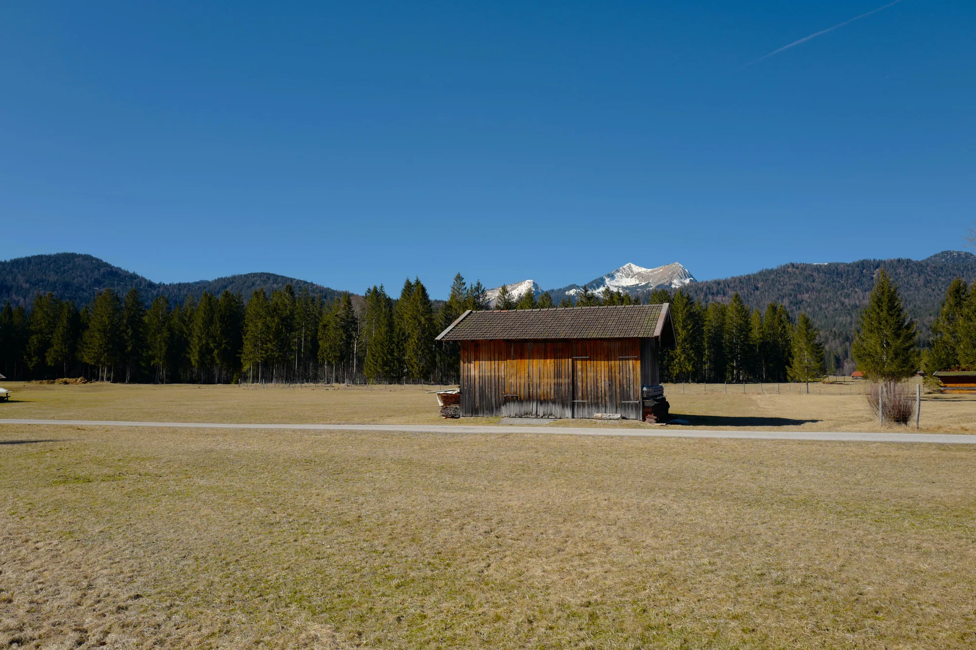 Un fienile rustico con le montagne e gli alberi dietro