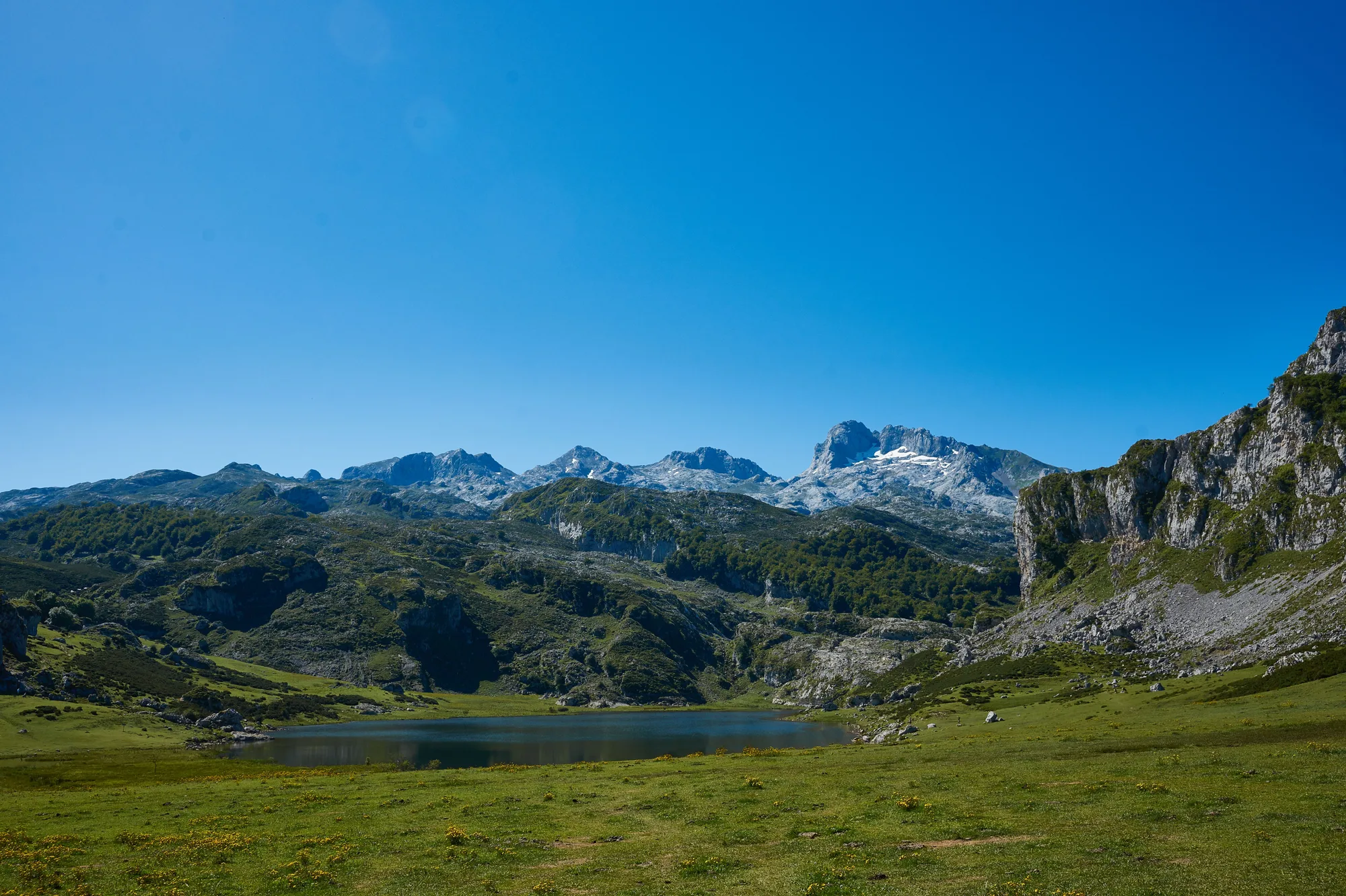 Un lago alpino e le montagne, sotto il cielo sereno